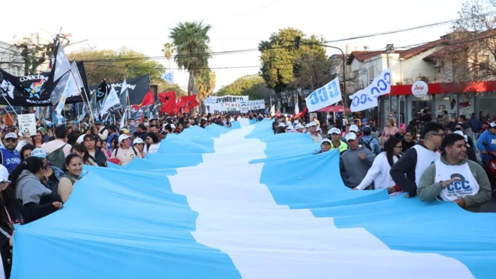 personas marchando sosteniendo bandera
